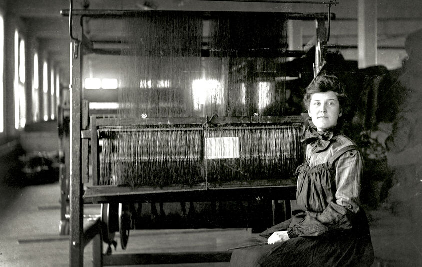 black and white photo of women by loom