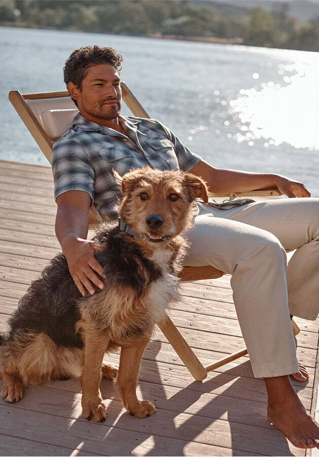 Man sitting outside with dog wearing Pendleton shirt