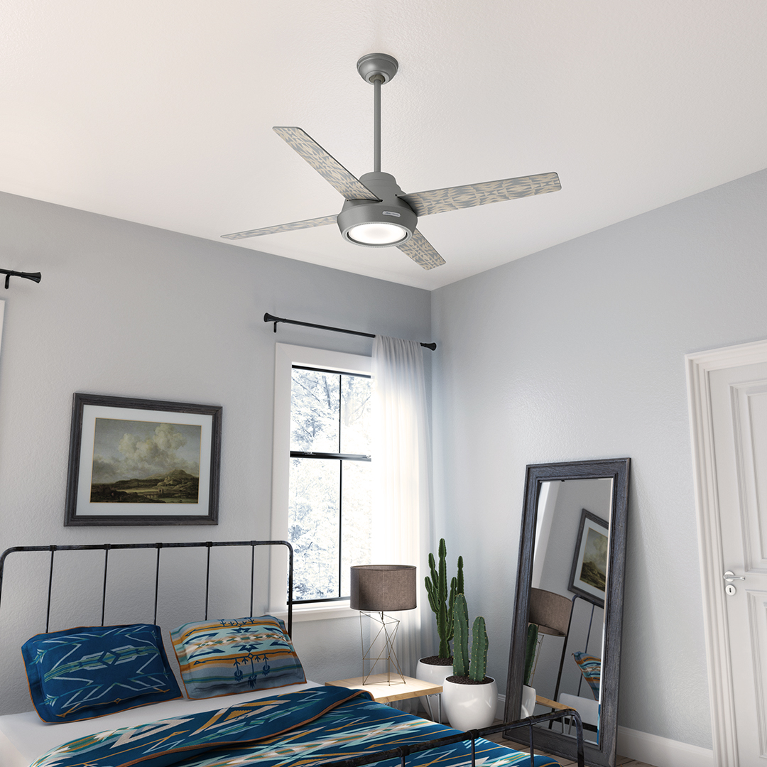 A bedroom with that features the silver Pendleton x Hunter fan. The room has white walls, an iron bed, and the bed has a Pendleton Star Watchers blanket and pillow shams.