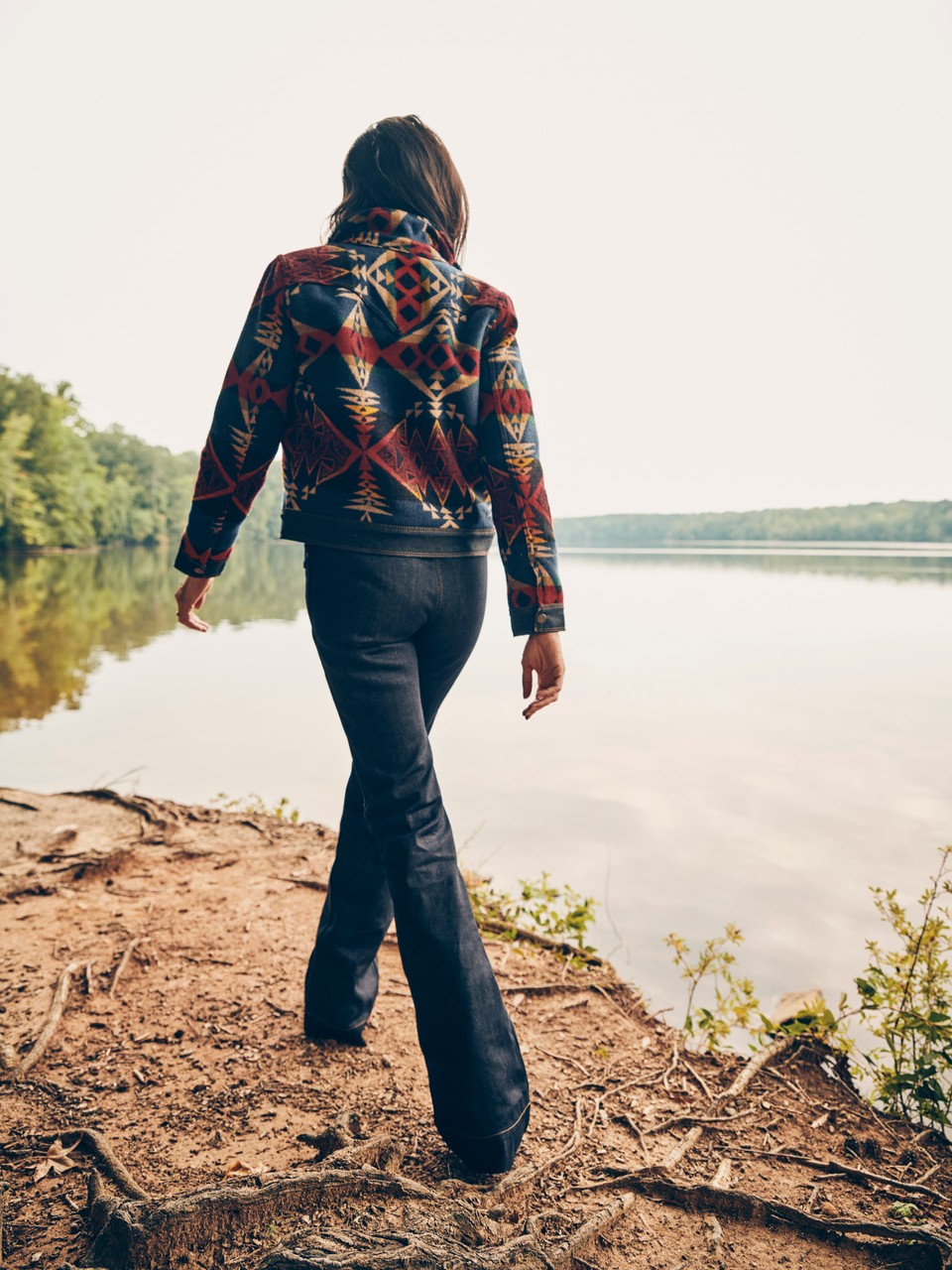 A woman walks along the shore wearing a Pendleton-Wrangler jacket.
