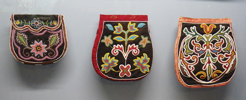 Three beaded bags by Native American artists hang behind glass at the Maryhill Museum of Art.