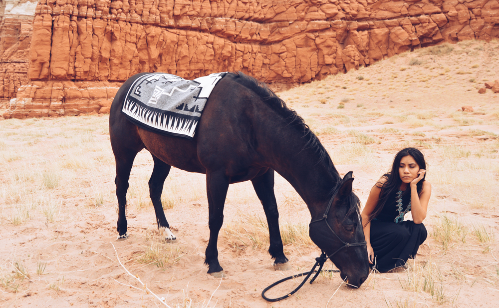 Shondina_Yikasbaa and a horse, horse wearing Pendleton saddle blanket