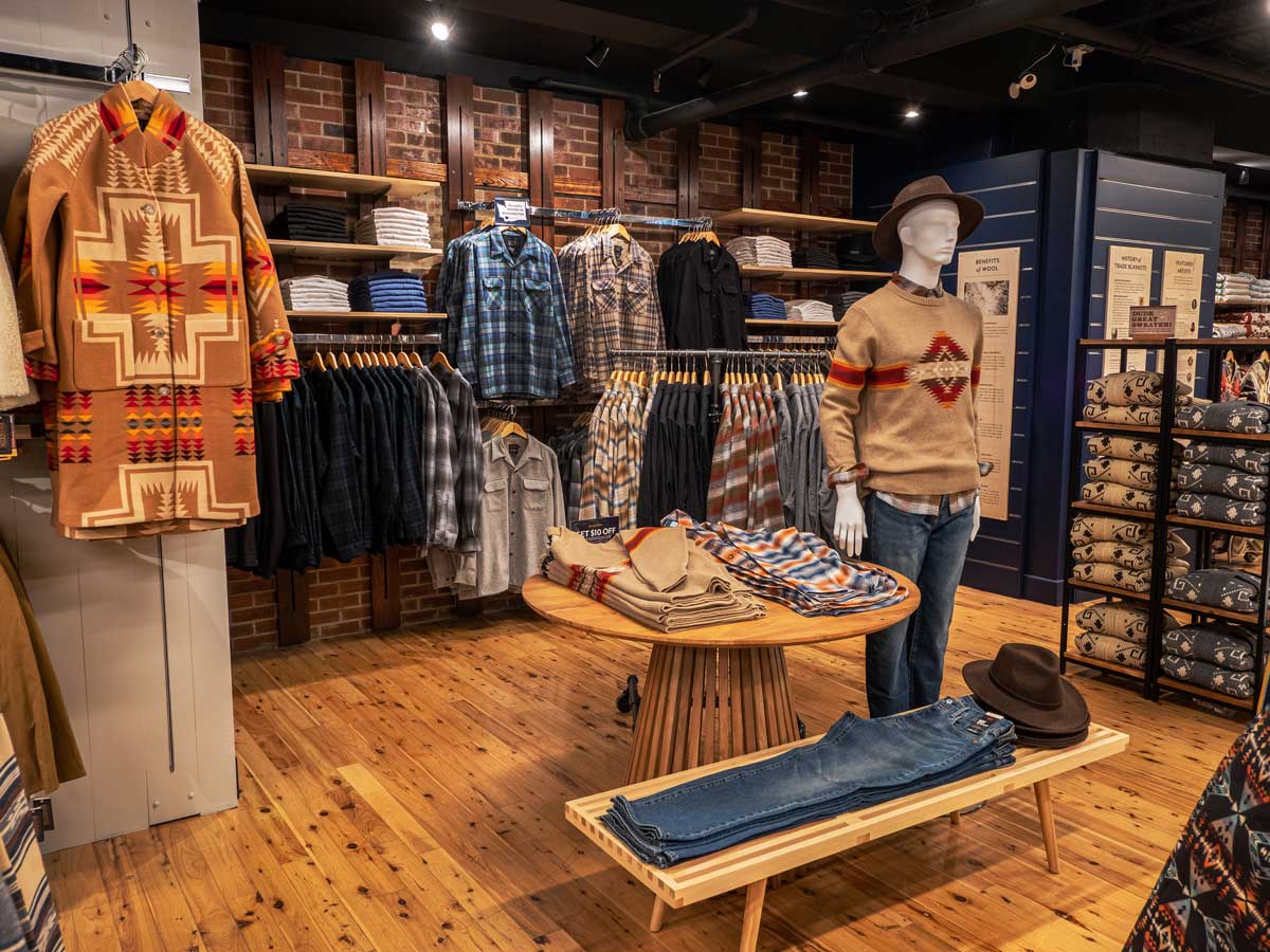 Another interior shot showing Pendleton apparel on display on mannequin, hung on wall fixutures, folded on shelves and table.