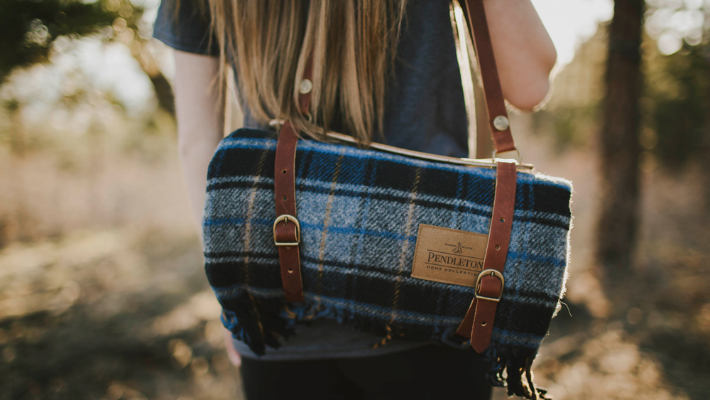 Kathleen_Peachey_photo of a woman carrying a Motor Robe in a leather strap carrier.