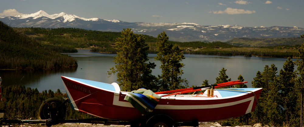 Greg;s beauriful wooden boat, a replica of the original Portola, by a lake.