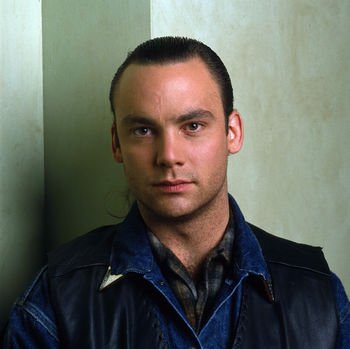 Eric Dare as leo in a plaid Pendleton shirt.