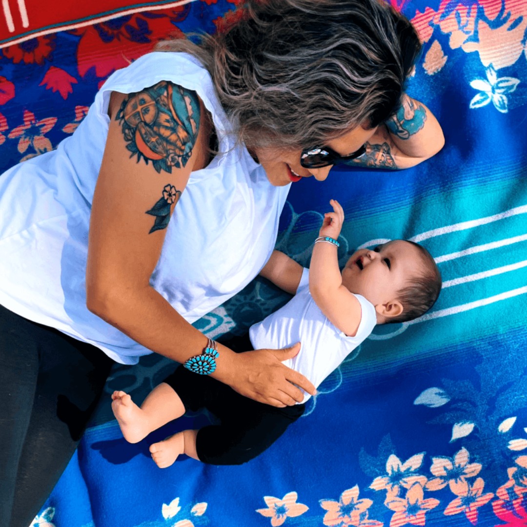 Emma Robbins and her daughter on the Pendleton blanket Ms. Robbins designed for the DigDeep Water Project blanket by Pendleton Woolen Mills.