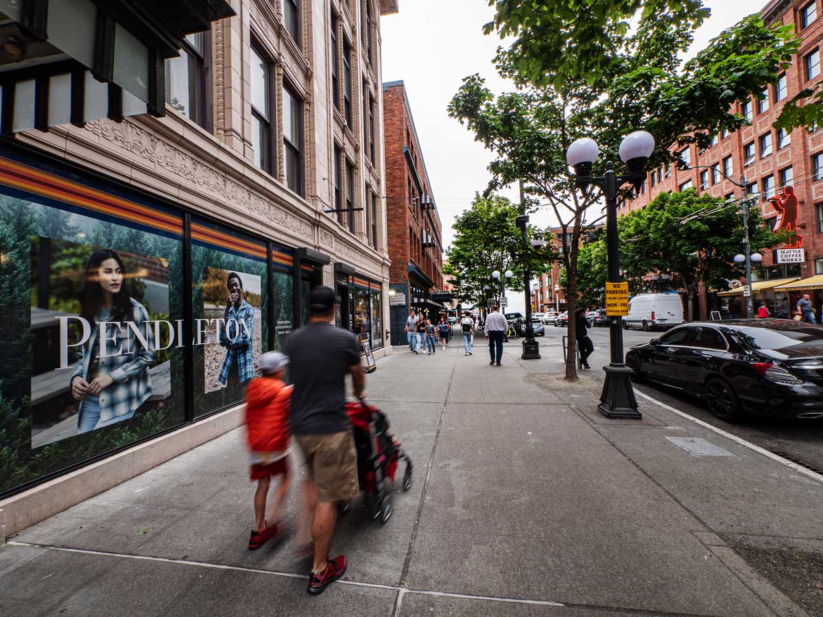 Sidewalk in front of the Seattle Pendleton store with people in motion walking past.