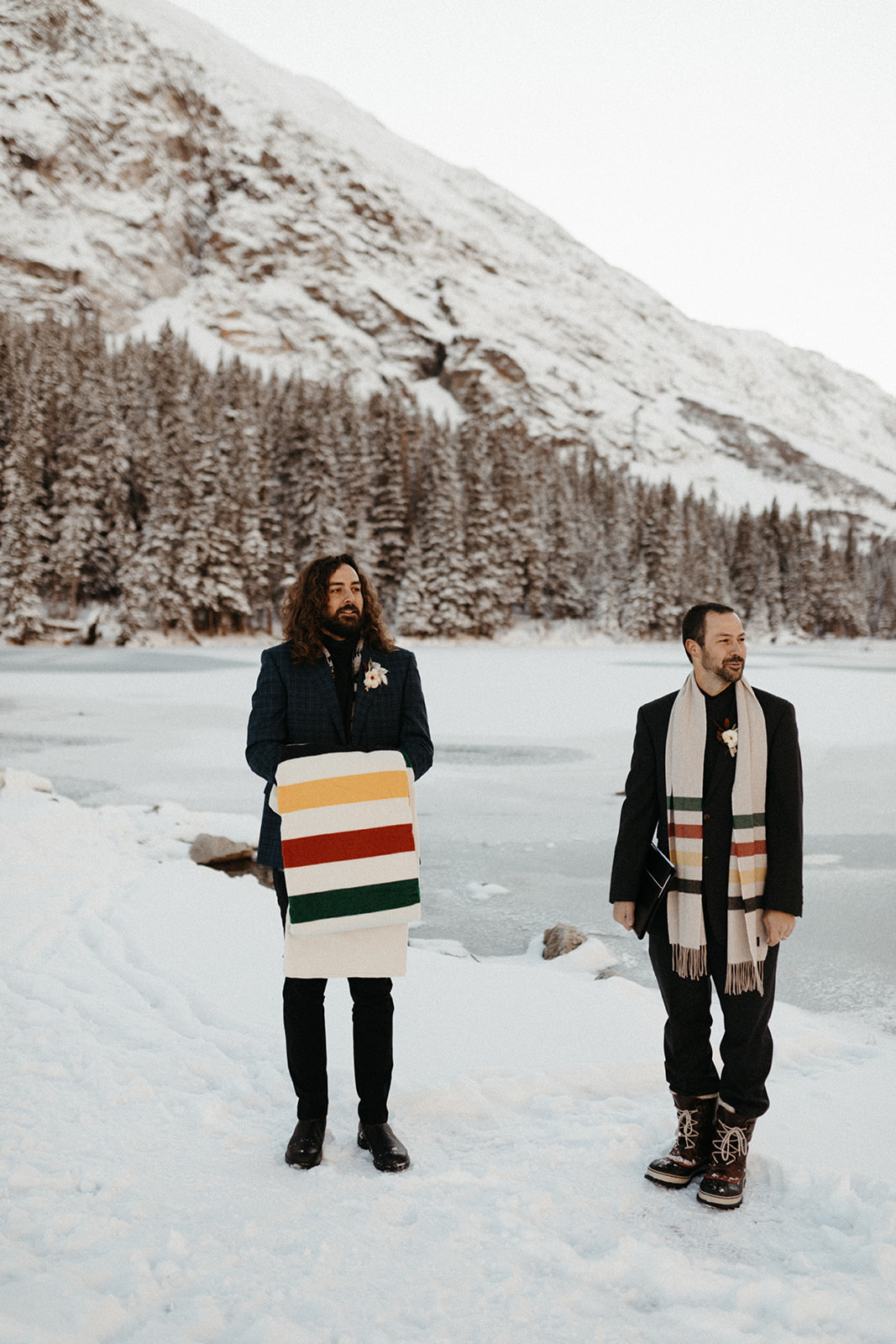 The groom waits with the officiant in the snowy mountains of Breckenridge, Colorado. 