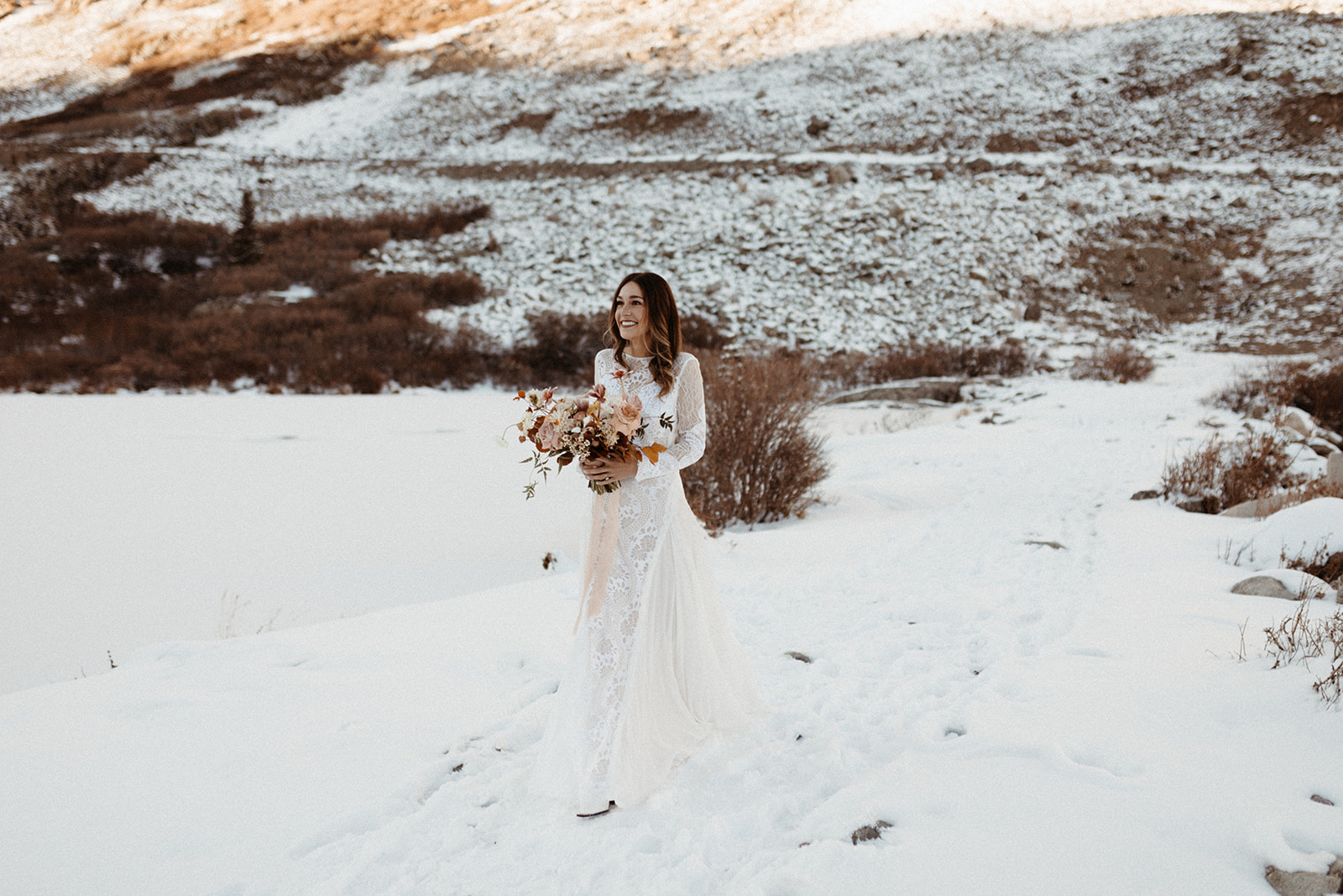 The bride approaches in a white wedding dress on the white sow, holding beautiful flowers. 