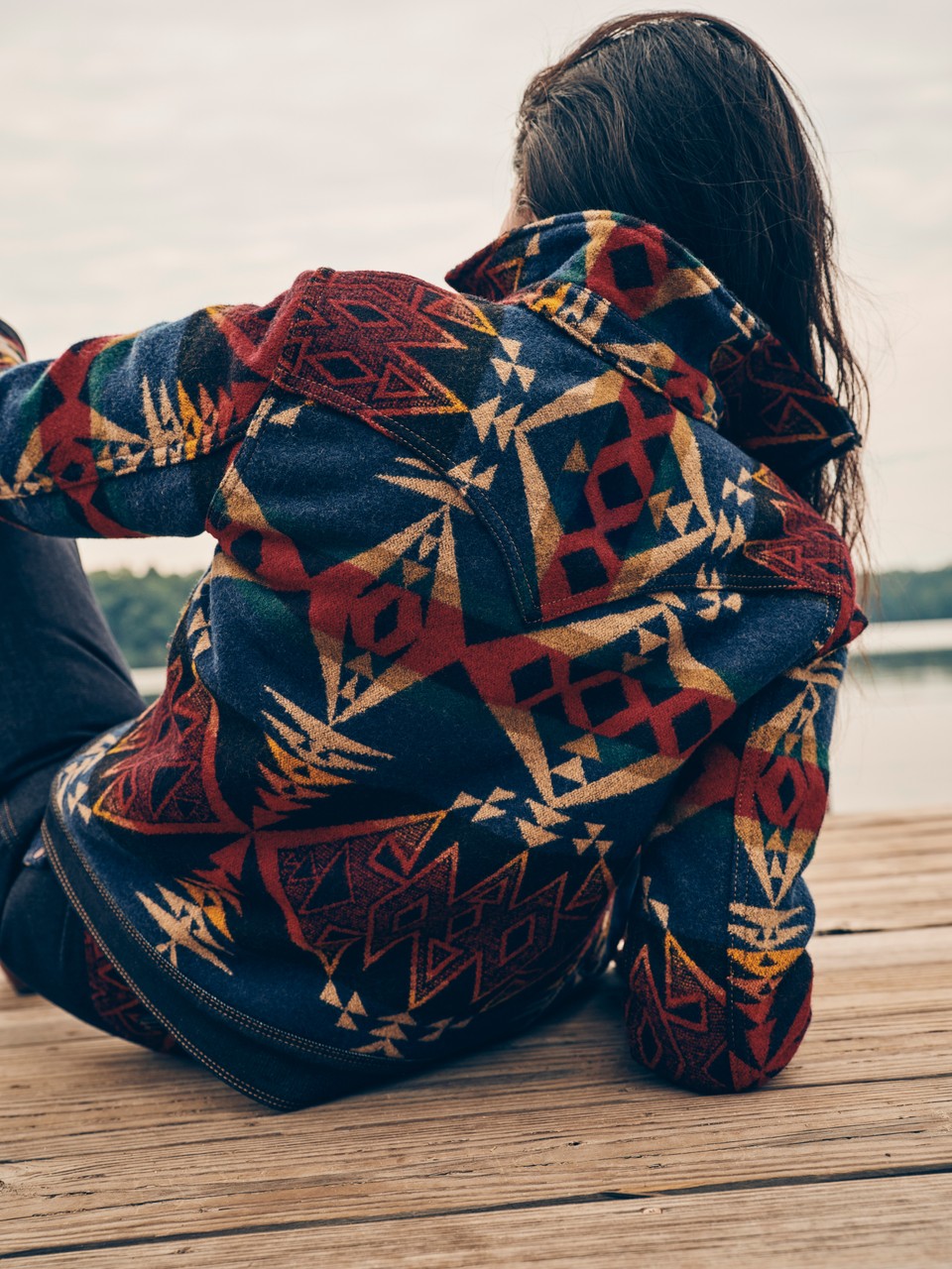 A woman reclines on a dock.