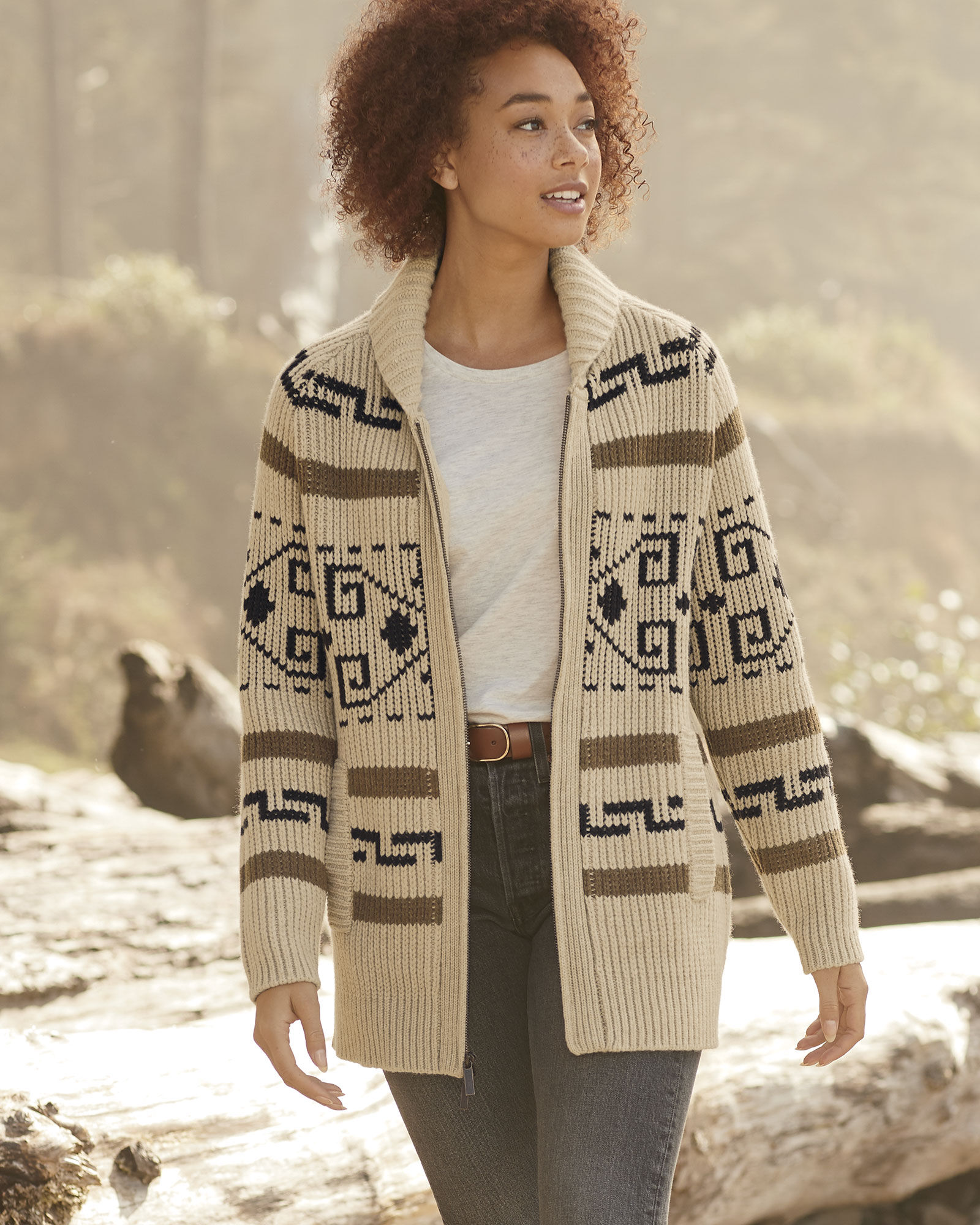 A woman walks on the beach wearing a Westerley cardigan by Pendleton.