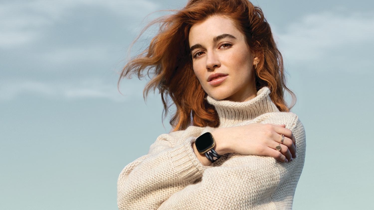 young woman wearing a white sweater and a Pendleton Fitbit device