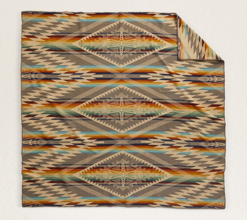 The Summerland blanket by Pendleton, in shades of tan and taupe with accent stripes of gold, orange, turquoise and dark brown.