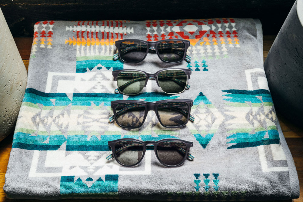 Four pair of Pendleton x Shwood sunglasses rest on a folded Chief Joseph towel, by Pendleton.